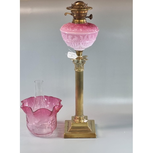 71 - Early 20th century double oil burner lamp having cranberry glass shade above a pink opaline glass mo... 