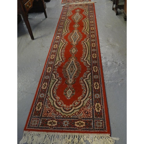 495 - Pair or Persian design red ground floral and foliate runners with an arrangement on central medallio... 