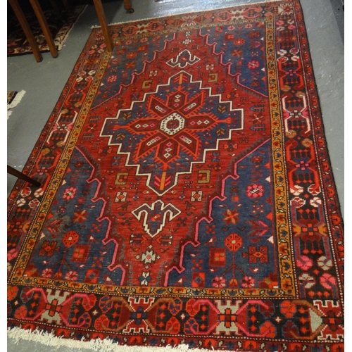 496 - Shiraz red ground geometric and foliate carpet with central medallion.  195x128cm approx.  (B.P. 21%... 