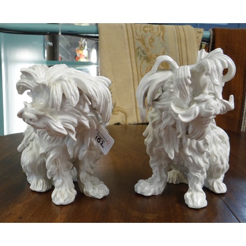 161 - Pair of continental porcelain Blanc de Chine seated fireside dogs, blue mark to the underside.  (2) ... 