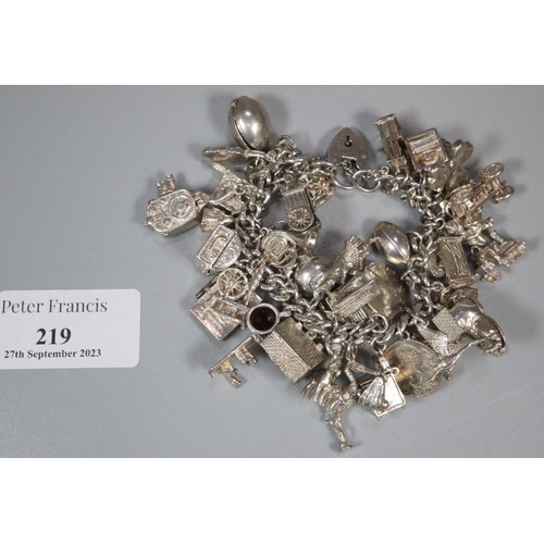 219 - Silver charm bracelet with a large collection of assorted charms. 4 troy ozs approx. 
(B.P. 21% + VA... 