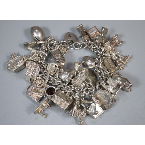 219 - Silver charm bracelet with a large collection of assorted charms. 4 troy ozs approx. 
(B.P. 21% + VA... 