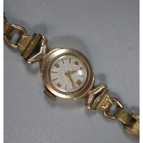 242 - A ladies 9ct gold faced watch with plated strap. 
(B.P. 21% + VAT)