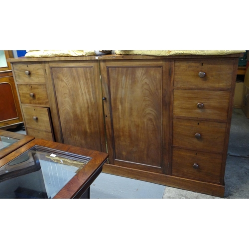 493 - Victorian mahogany press cupboard of rectangular low proportions, the central doors with shelves, fl... 