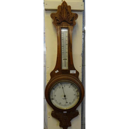 480 - Early 20th century carved oak aneroid barometer marked 'Felix Martin, Swansea'.  (B.P. 21% + VAT)