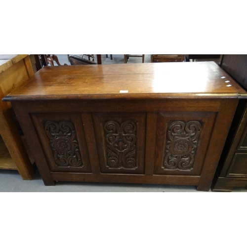 484 - 18th century style carved oak coffer, the moulded top above three carved and fielded panels standing... 