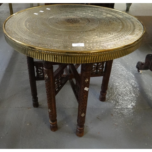 551 - Indian brass top table on hardwood folding stand.  (B.P. 21% + VAT)