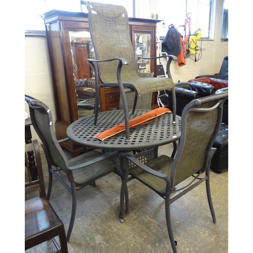 578 - Patinated aluminium dining table and chairs set with weather proof wicker-work panels.  (5)   (B.P. ... 