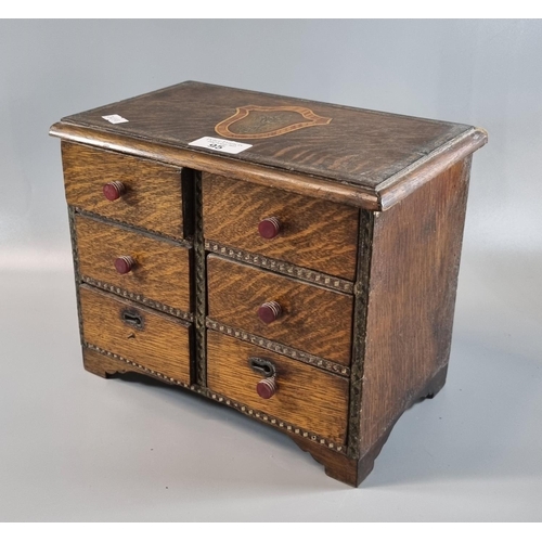 95 - Unusual oak miniature straight front chest of six drawers on bracket feet with central armorial to t... 