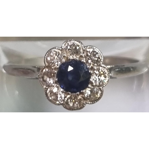 199 - Platinum eight stone diamond daisy ring with central sapphire stone.  2.2g approx.  Size K1/2.   (B.... 