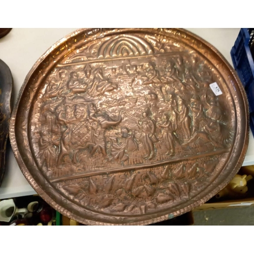 353 - Repoussé decorated copper tray, overall with a multitude of Indian figures together with a helmet sh... 