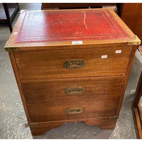 499 - Modern teak leather top chest of three drawers, of narrow proportions, with brass mounts and brass r... 