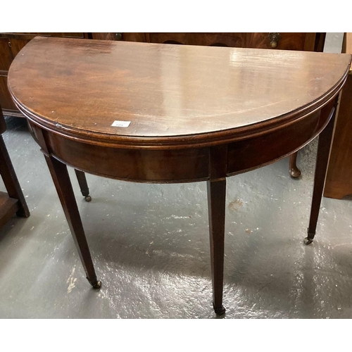 505 - George III mahogany demi-lune fold 0ver tea table on tapering legs and casters.  (B.P. 21% + VAT)