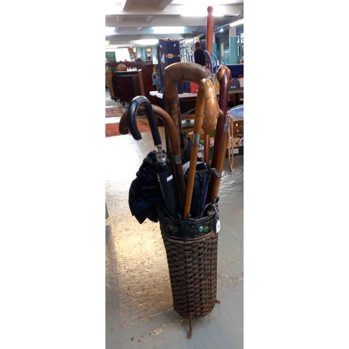 530 - Modern wicker work and metal umbrella stand with a collection of walking sticks, umbrellas, parasol ... 