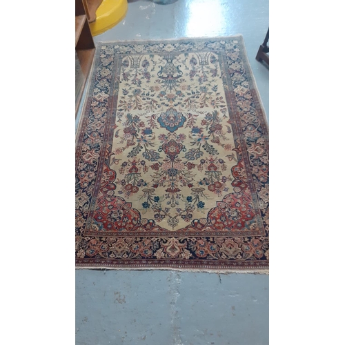 534 - Persian design carpet on a cream and navy ground decorated with flowers and foliage.  203x132cm appr... 