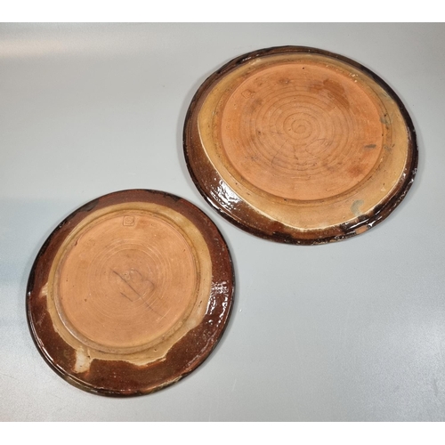 151 - Michael Cardew, two similar pottery slipware plates in brown and cream. Impressed marks to the under... 