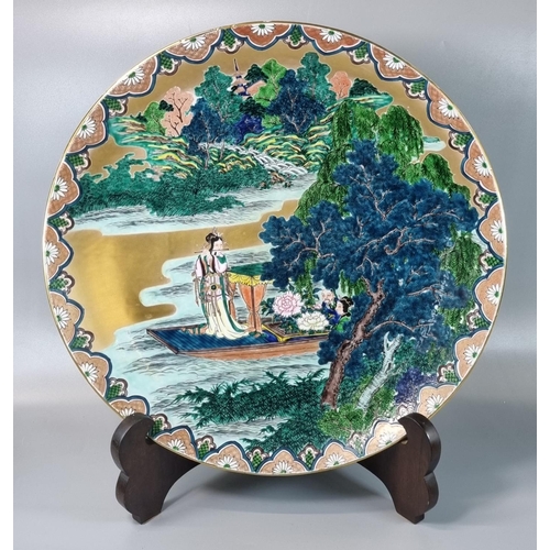 167 - Japanese porcelain Kutani polychrome charger depicting a woman on a boat playing a flute in a landsc... 