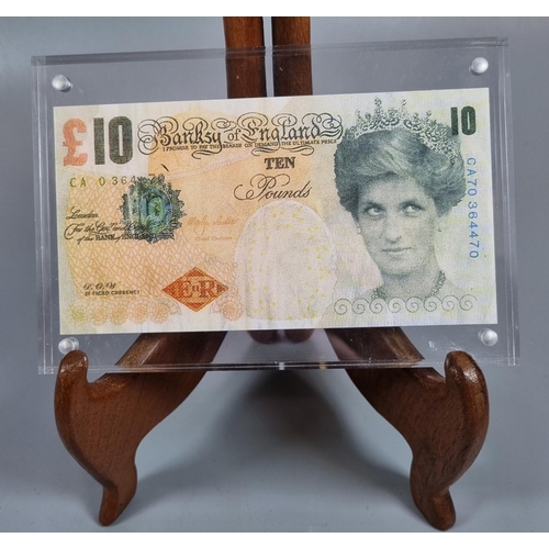 262 - Banksy, a Di'Faced £10 note, an original Bank of England £10 note, the Queen's face substituted with... 