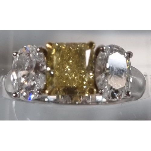 335 - 18ct white gold fancy grade three stone diamond ring, the central stone drawing yellow colour, two b... 