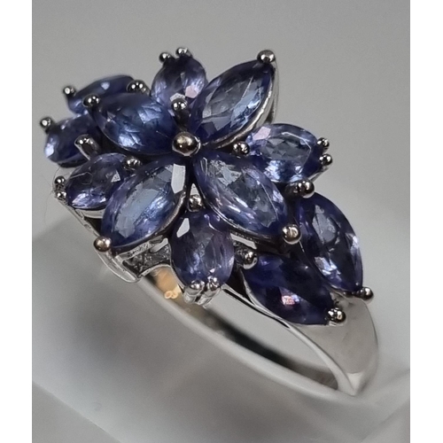 341 - 18ct white gold Iliana blue stone flowerhead design ring. Probably Tanzanite.  4.78g approx.  (B.P. ... 