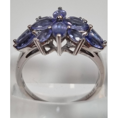 341 - 18ct white gold Iliana blue stone flowerhead design ring. Probably Tanzanite.  4.78g approx.  (B.P. ... 