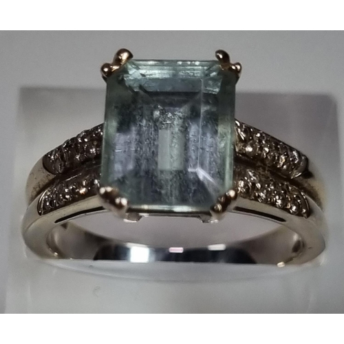 345 - White metal aquamarine and diamond ring, the central stone flanked by an arrangement of small diamon... 