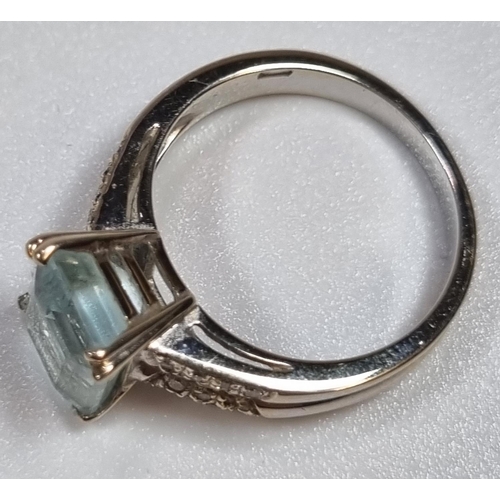 345 - White metal aquamarine and diamond ring, the central stone flanked by an arrangement of small diamon... 