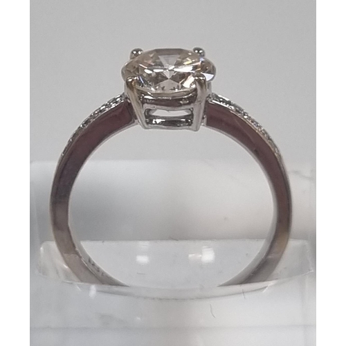 366 - 18ct white gold diamond solitaire ring, the central stone flanked by tiny diamonds to each side.  1.... 