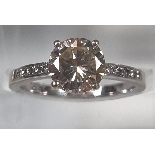 366 - 18ct white gold diamond solitaire ring, the central stone flanked by tiny diamonds to each side.  1.... 