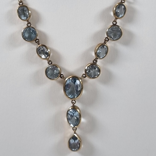 380 - 9ct gold eleven stone blue topaz necklace.  10g approx.  (B.P. 21% + VAT)