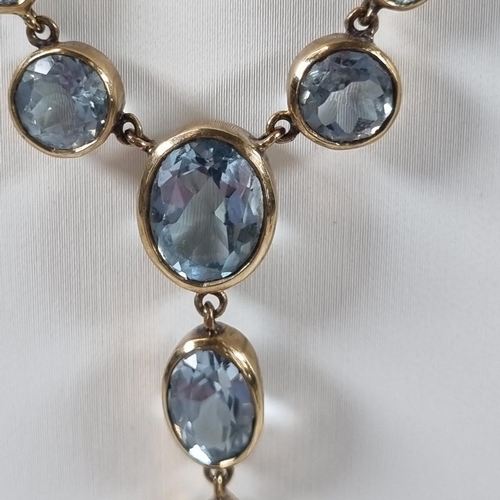 380 - 9ct gold eleven stone blue topaz necklace.  10g approx.  (B.P. 21% + VAT)