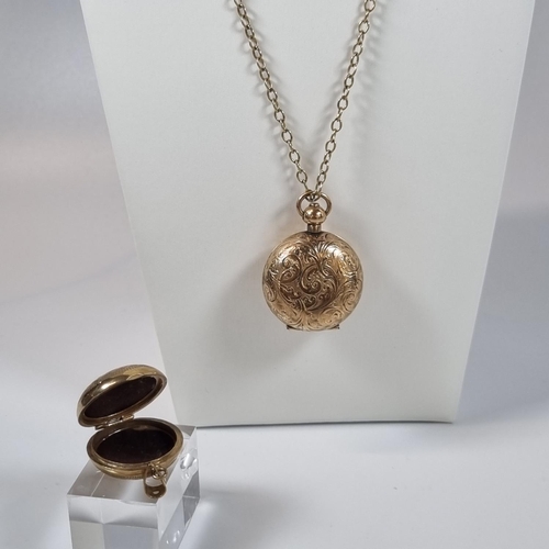 384 - Dennison gold plated sovereign holder with engraved decoration on a 9ct gold chain together with a 9... 