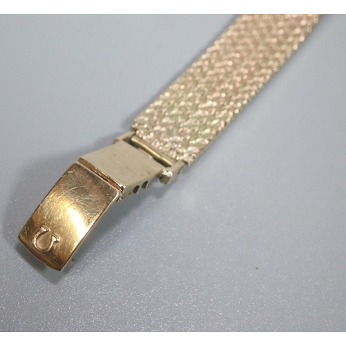 411 - 9ct gold ladies bracelet watch, with satin face having baton numerals ans mesh integral Omega bracel... 