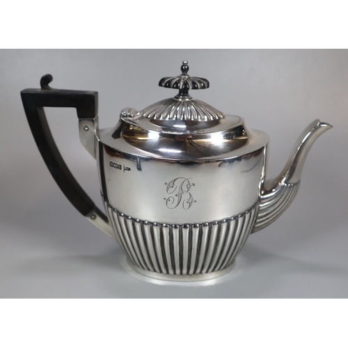 443 - Edward VII silver fluted three piece service, the teapot with geometric ebonised handle, to include:... 