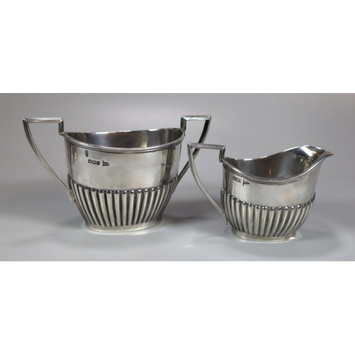 443 - Edward VII silver fluted three piece service, the teapot with geometric ebonised handle, to include:... 