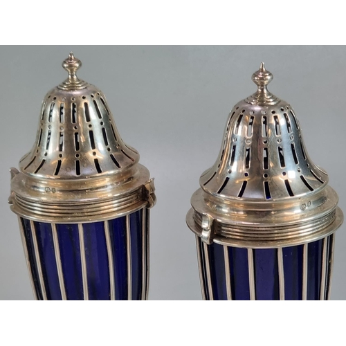 447 - Pair of Edward VII silver sugar casters having Bristol Blue glass liners standing on circular bases,... 