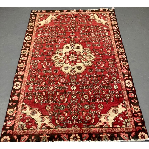 468 - Red ground Persian Hamadan Village rug with central floral medallion.  208x127cm approx.