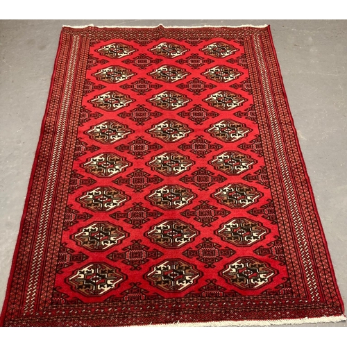 469 - Rich red ground Turkmen double knot rug, with traditional Bukhara designs.  186x125cm approx.  (B.P.... 