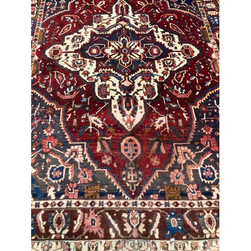 482 - Rich red blue ground Persian Bakhtiari village rug with large central floral and foliate medallion. ... 