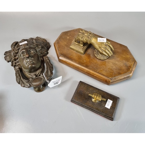 102 - Vintage brass door knocker in the form of a hand on wooden moulded base. Together with another brass... 