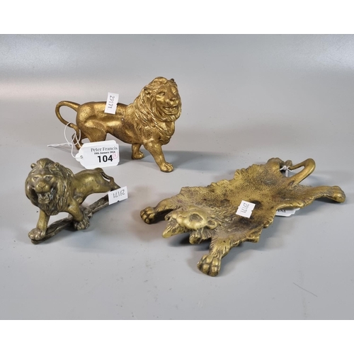 104 - Gilt metal study of a male lion, together with a brass study of a male lion and a brass lion rug. (3... 