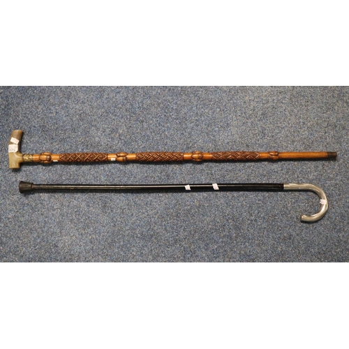 175 - Ebonised walking cane with white metal handle together with an acorn carved walking stick with yello... 