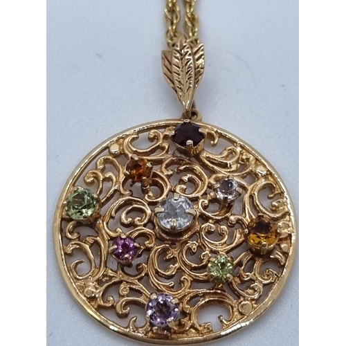 253 - 9ct gold pierced circular pendant inset with multicoloured semi-precious stones on a 9ct gold chain.... 