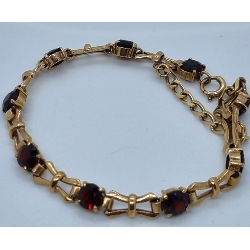 257 - 9ct gold and garnet bracelet.  12.2g approx.   (B.P. 21% + VAT)