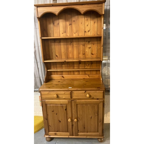 564 - Modern pine dresser with three shelf boarded rack back, two drawers and two cupboards on bun feet.  ... 