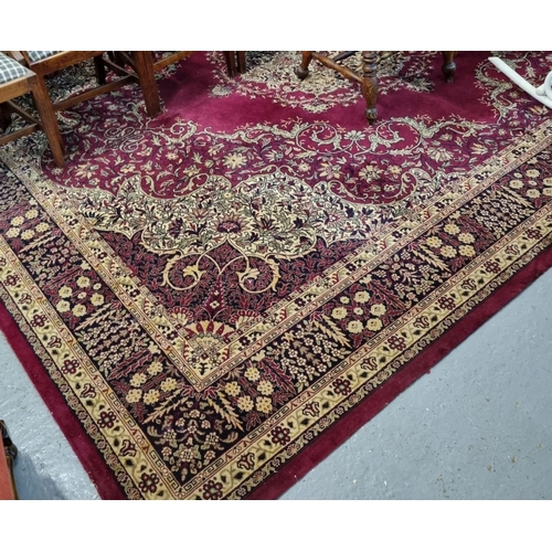 570 - Large modern maroon ground Persian design carpet with large central floral medallion flanked by repe... 