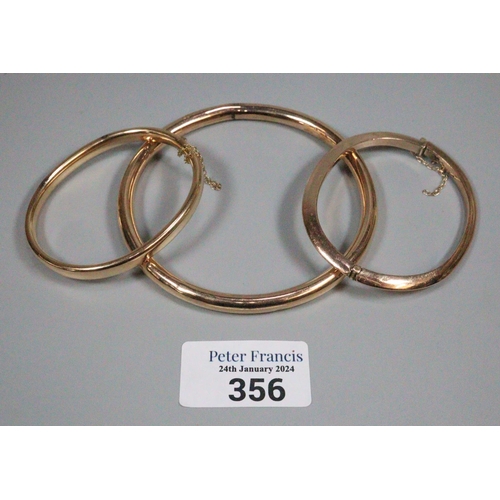 356 - Two 9ct gold bangles.  23.5g approx., together with another yellow metal bangle.  10.5g approx.  (3)... 