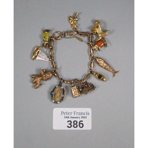386 - 9ct gold charm bracelet with assorted charms including: kitten with ball, articulated fish, rabbit, ...