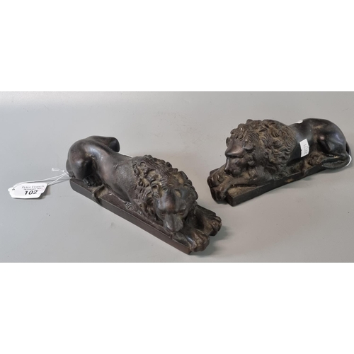 102 - Pair of bronze recumbent male Lions on rectangular bases.  (2)   (B.P. 21% + VAT)