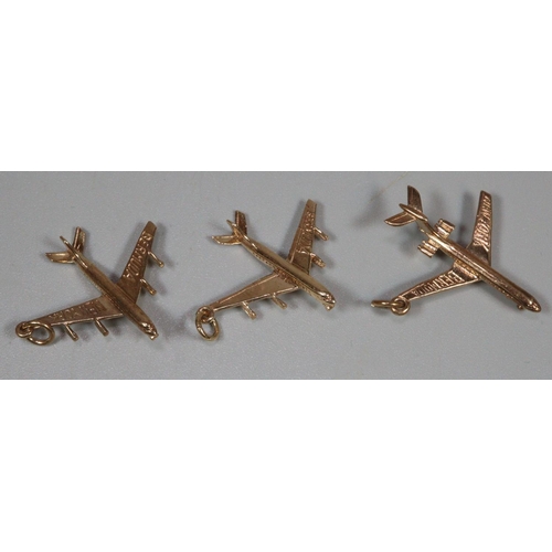 229 - Three 9ct gold charms in the form of aeroplanes marked 'Bermuda New York'. 6.3g approx.  (B.P. 21% +... 